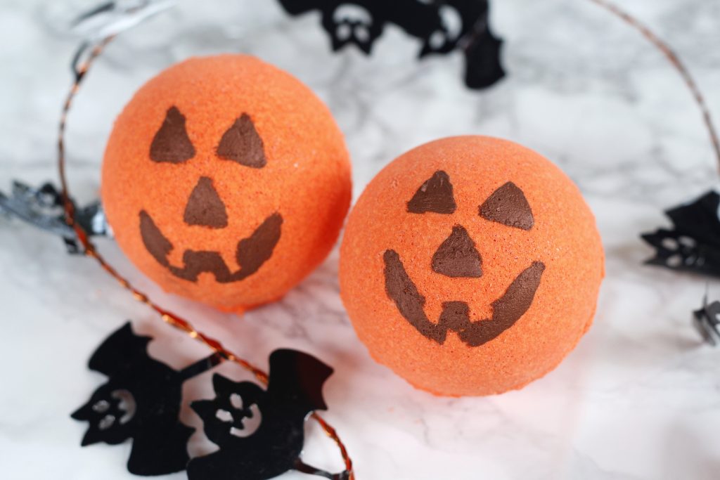 This is a cute Halloween DIY idea - Jack-o'-lantern bath bomb recipe scented with essential oils. They make for a fun kids craft, homemade gift or decoration. #halloween #bathbomb #kidcraft #diy #pumpkin
