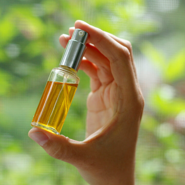 hand holding bottle with oil.