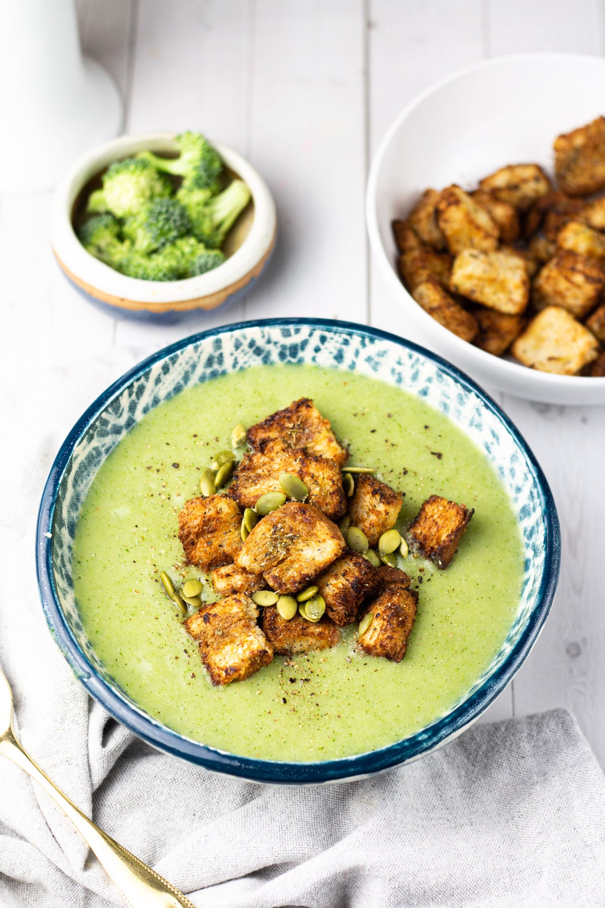 vegan cream of broccoli soup in bowl with croutons.