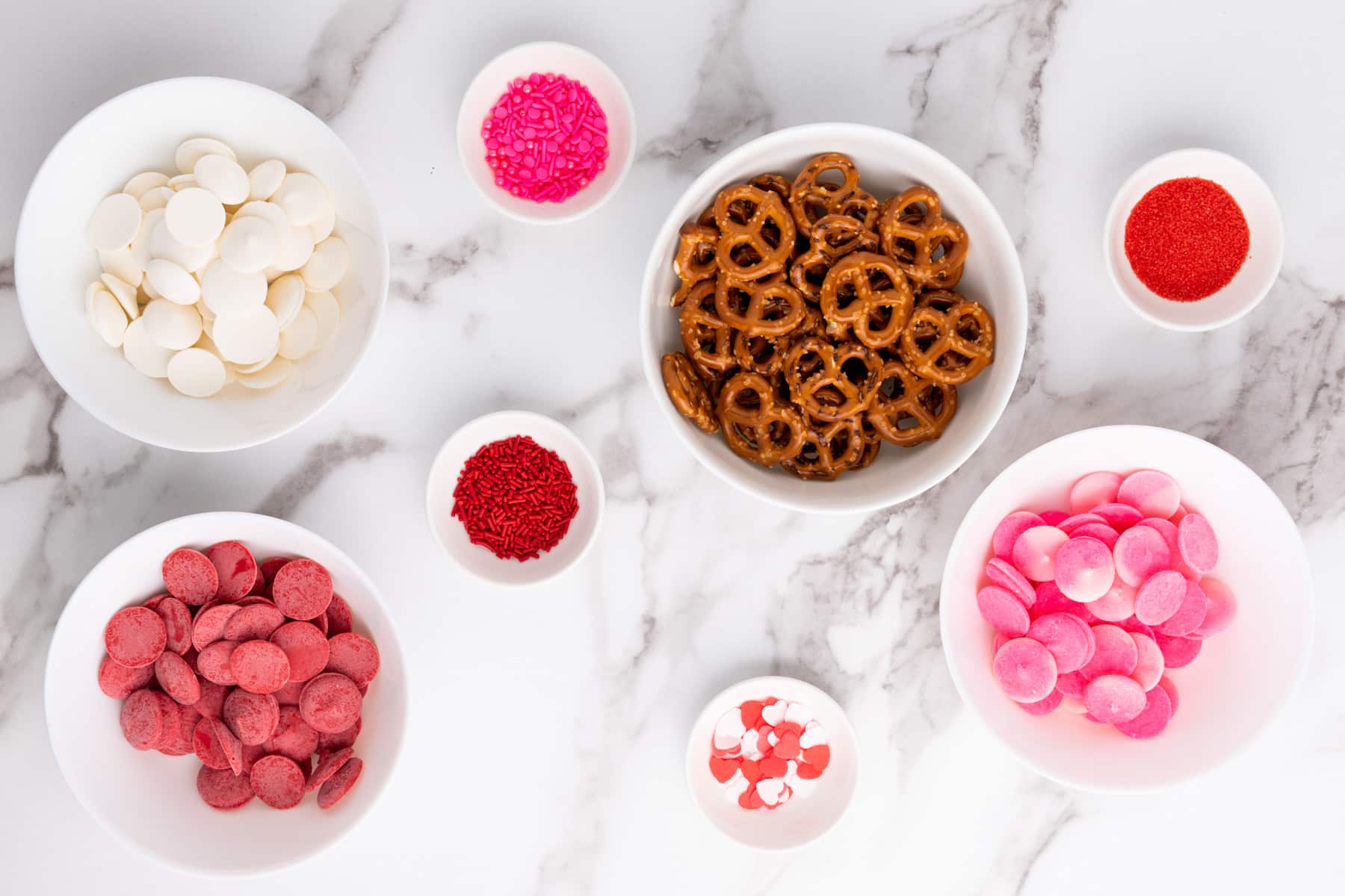 candy melts, pretzel twists and sprinkles in bowls.