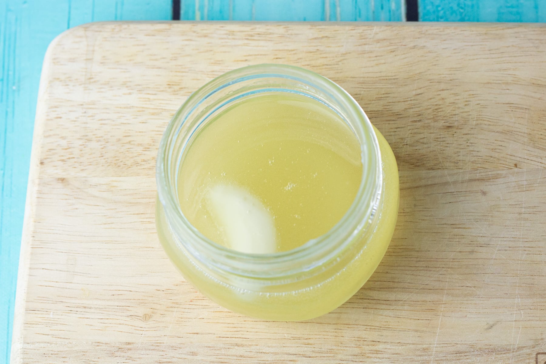 liquid body butter in glass jar.