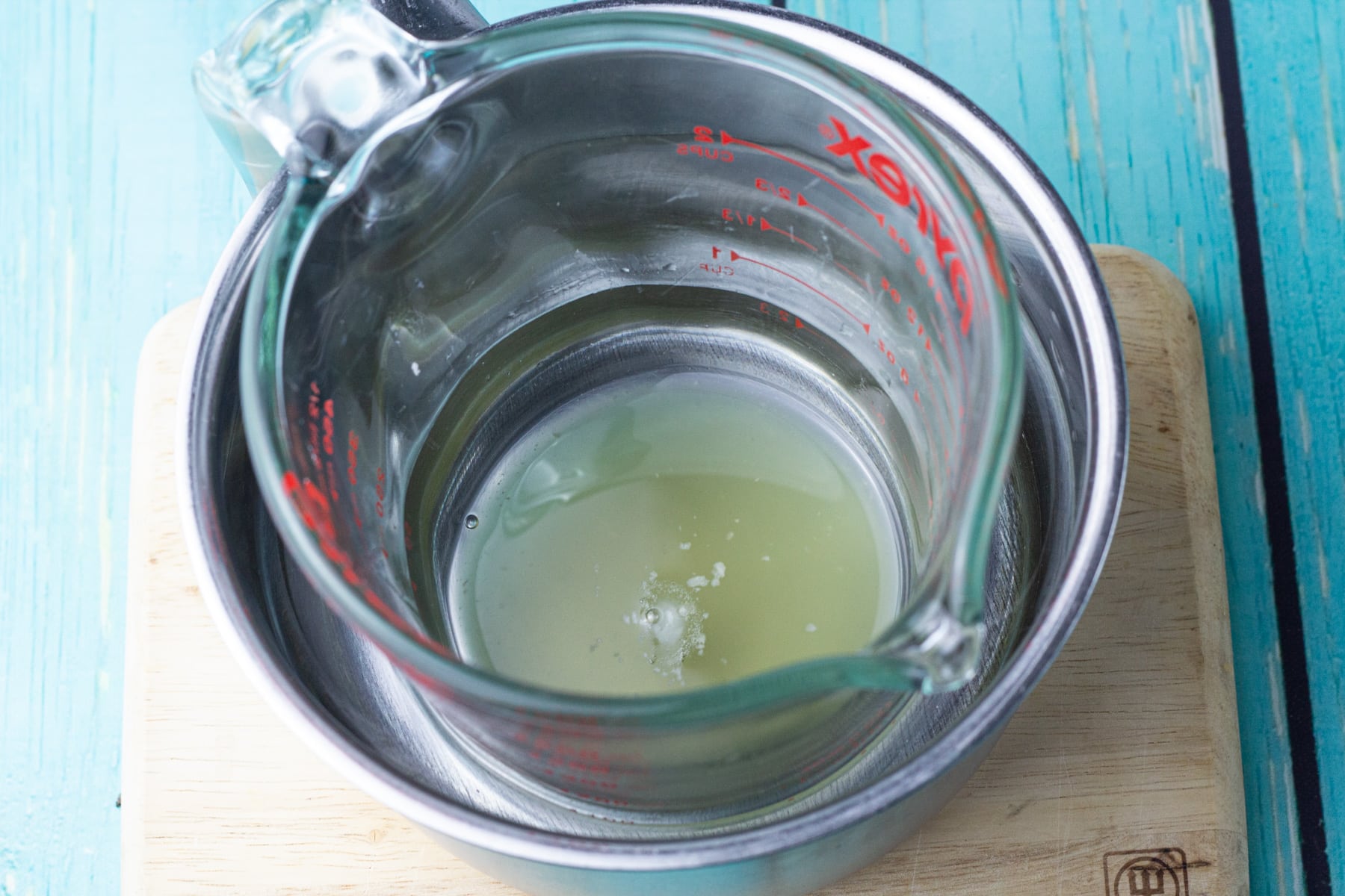glass cup in sauce pan with melted body butter.