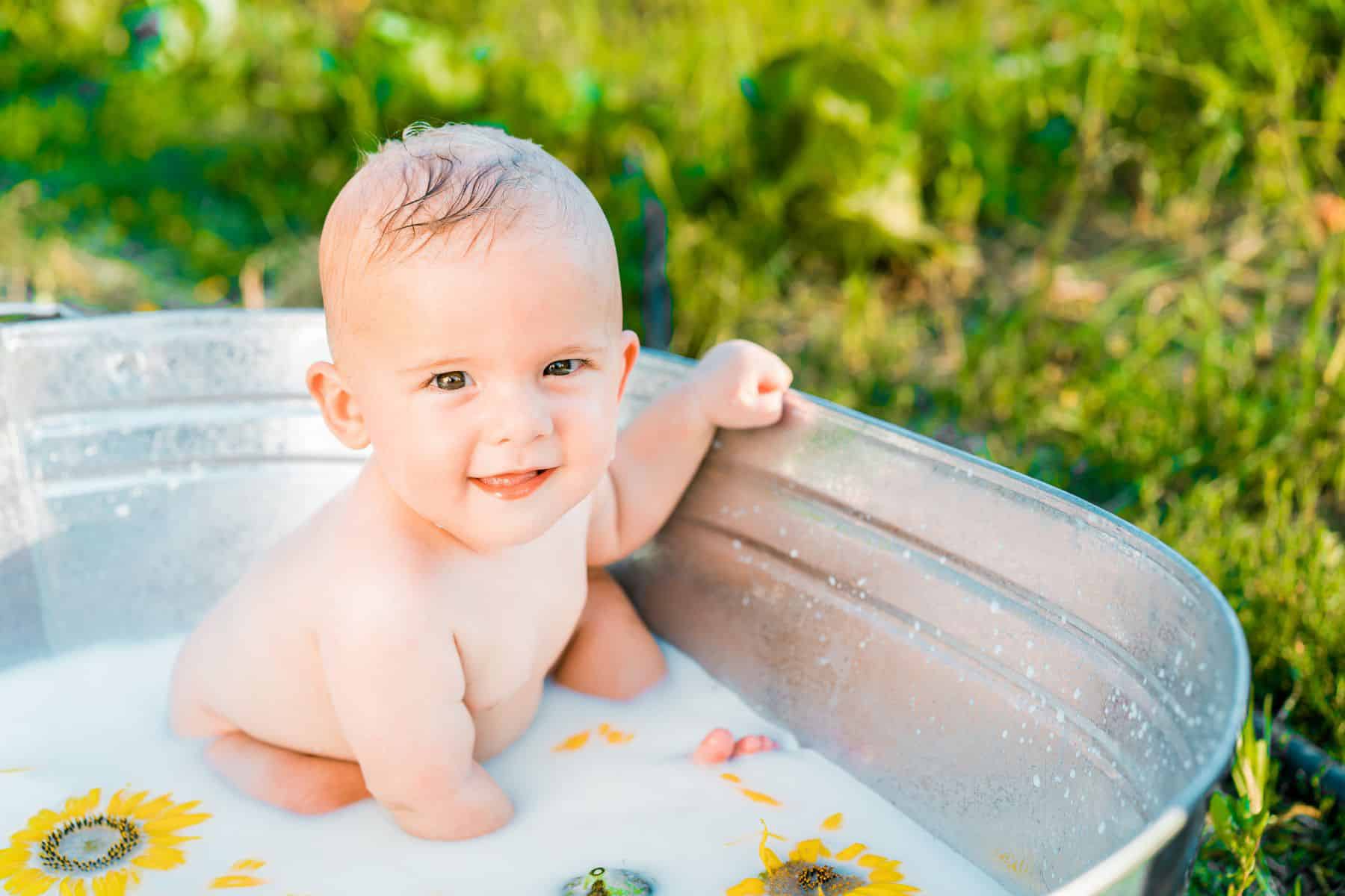 baby sitting in tub with milk bath.