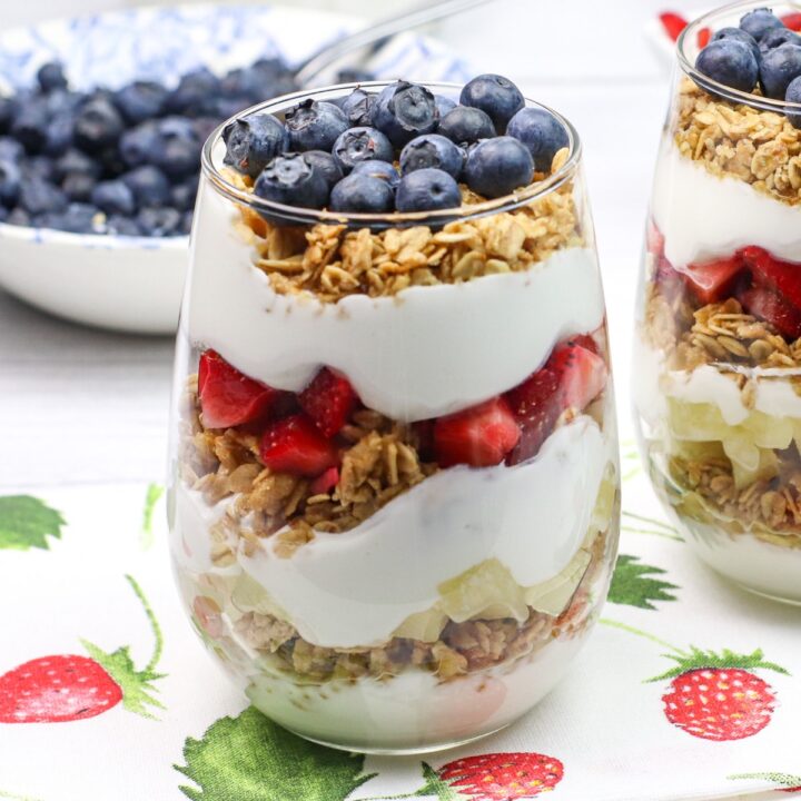 glass cup with layers of yogurt, granola and fruit.